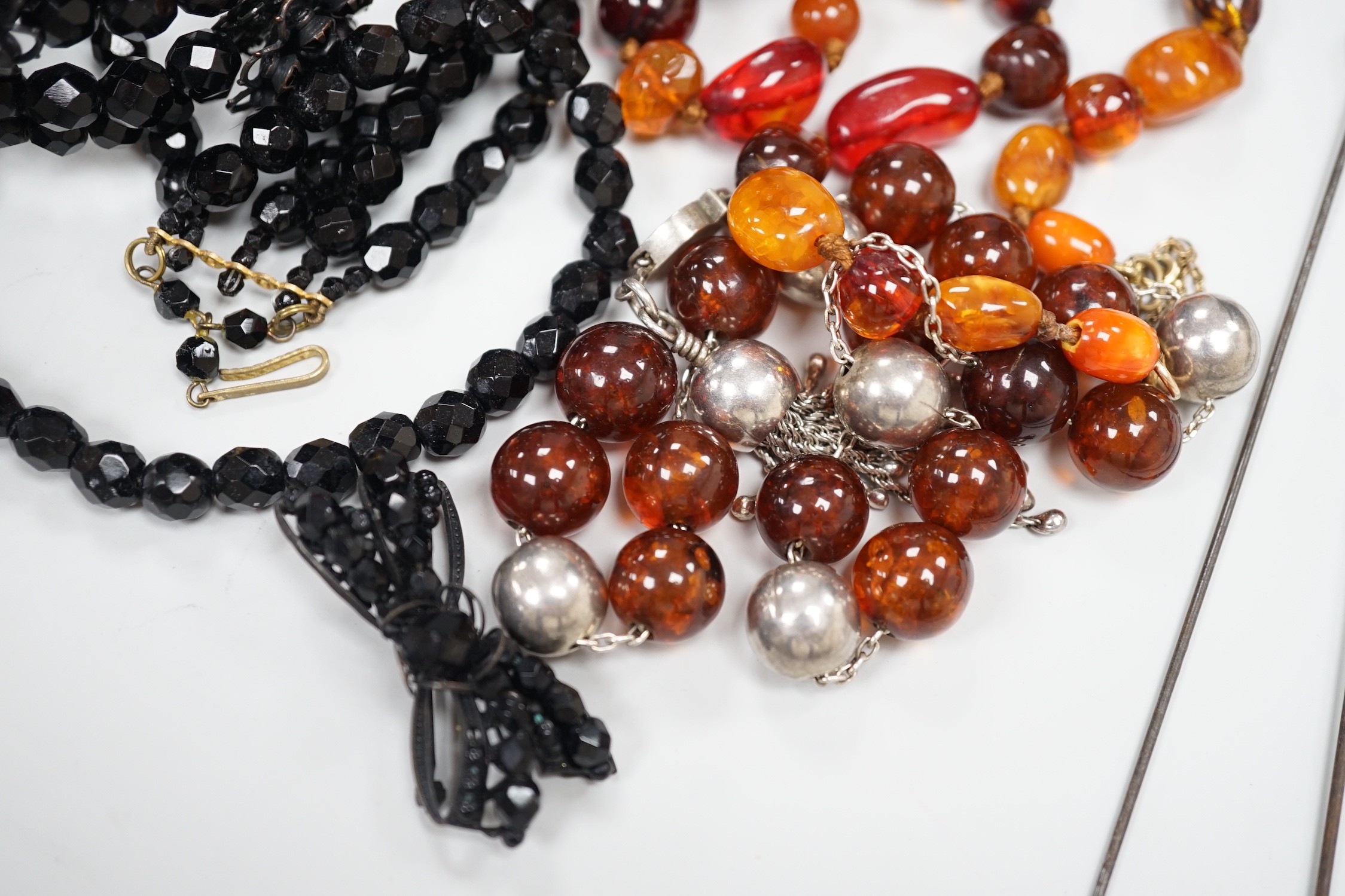 An early 20th century 9ct gold mounted hat pin by Charles Horner, 16cm one other 9ct mounted hat pin, a Margaret Haskell brooch and bracelet and three other items including amber necklace.